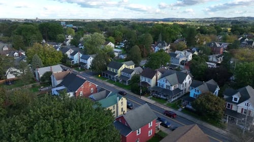 Aerial overhead shot of small American town. Drone establishing shot shows homes and housing along s