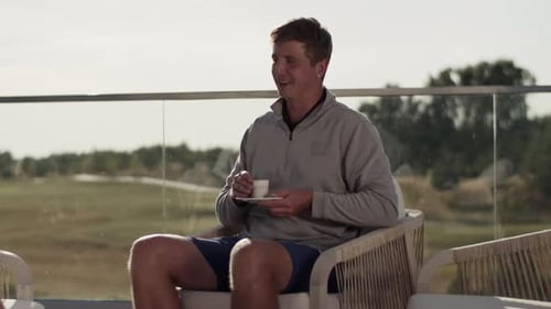 Man relaxes with morning coffee on rooftop patio