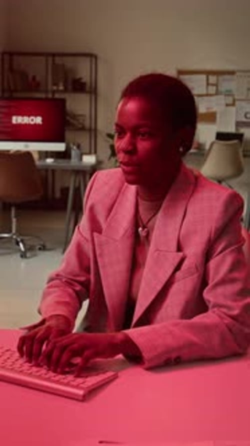 Businesswoman Typing at Computer Displaying Error Message