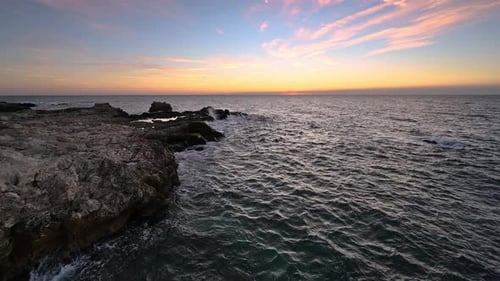 Rising sun at beautiful rocky coastline