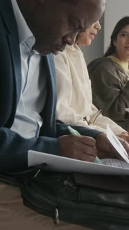 Vertical of Black Businessman Completing Visa Application while Queuing