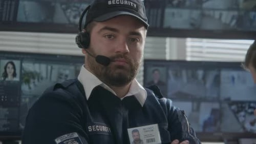 Security Officer Wearing Headset in Front of Monitors