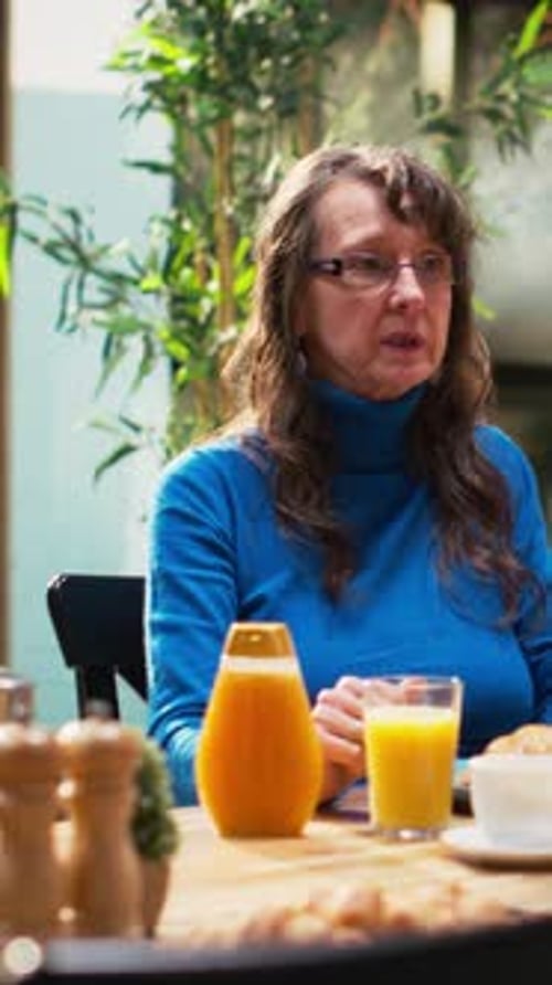 Woman Enjoying Breakfast with Orange Juice Indoors