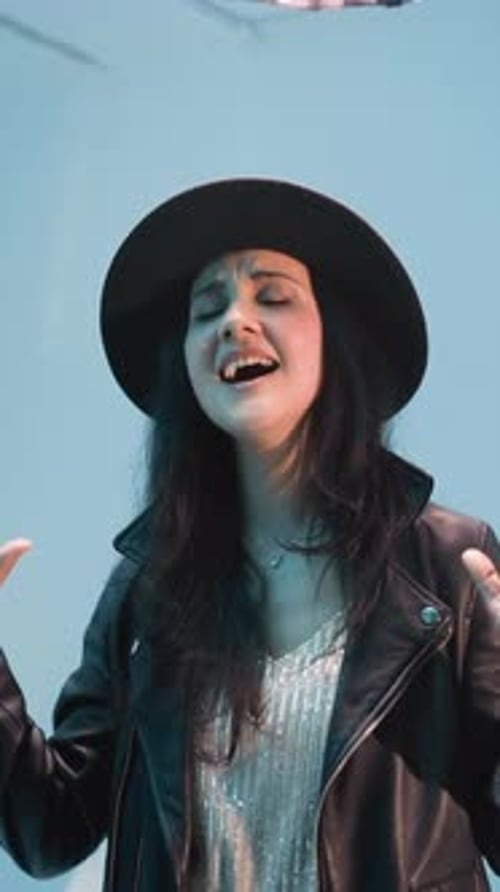 Stylish Woman in Hat Singing with Leather Jacket