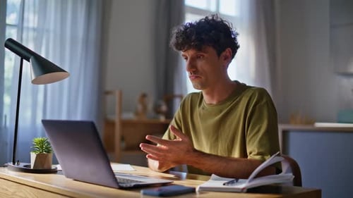 Man Using Laptop at Home at Desk