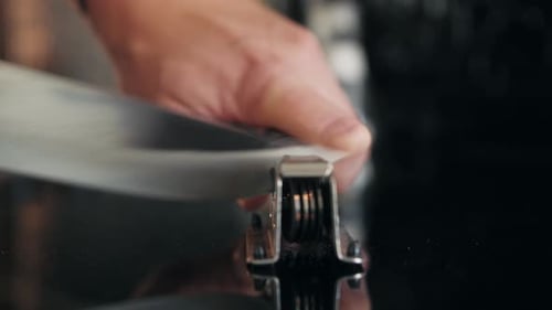 Man Sharpening the Knife with a Whetstone on a Wooden Background Close Up