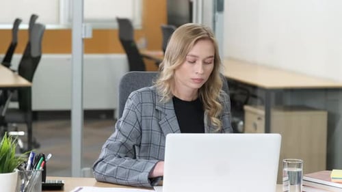 Woman Working with Laptop and Documents in Office