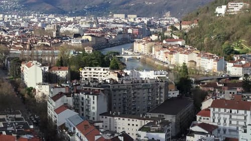 Aerial View of Grenoble City Center with Isere River Flowing Through Residential Buildings and Alps