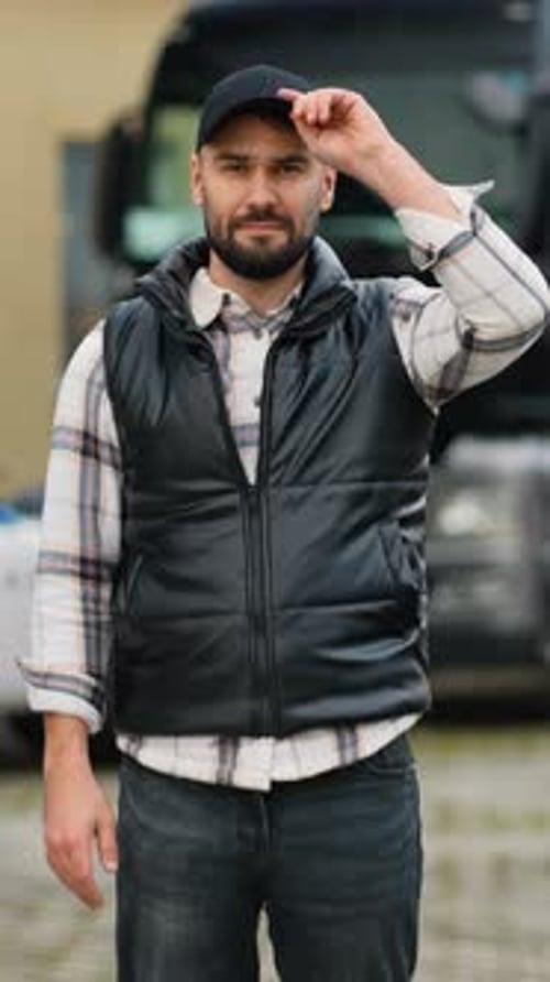 Professional Truck Driver Smiling in Front of His Semi Truck