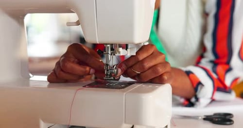 Hands, sewing machine and designer with cotton in workshop for manufacturing with fabric