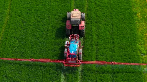 Pestizid-Spritztraktor, der während der Vegetationsperiode auf grünem Ackerfeld arbeitet, Landwirtschaftsfahrzeug ausbringen