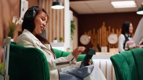 Traveler Using Tablet to Pass Time in Lounge Area at Hotel