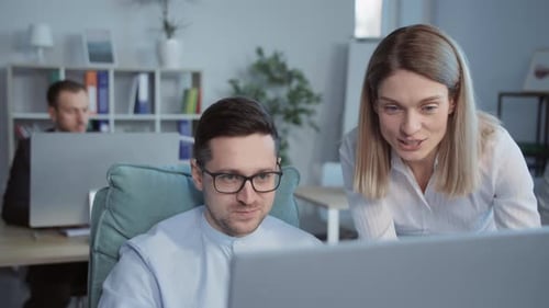 Close Up Man and Woman Talking Use Computer Working Together in a Modern Office On Background