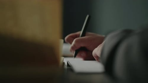 Hand Writes on Paper with Pen in Office