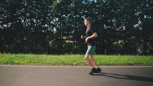 Young Man Running in Morning in Summer Runner Run Active Confident Hardy Man Running Side View