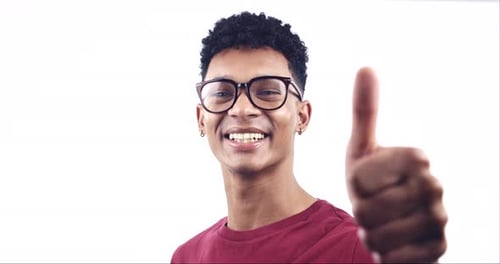 Thumbs up, face of man and happy in studio for winning, agreement and success on white background