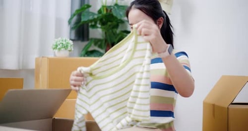 Young Woman Unboxing Fashion Clothing and Taking Selfie