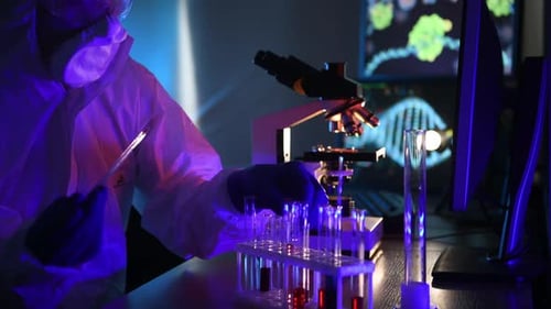 A man in biological defense works in a viral laboratory. Looks at samples in test tubes.