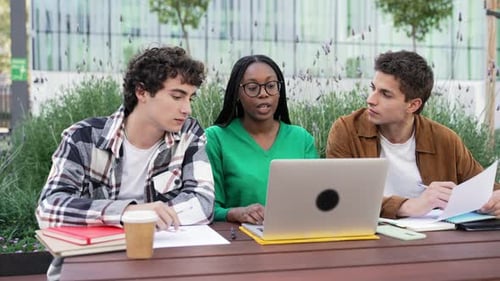African American Student Girl with University Friends Preparing for Lessons Sitting with Laptop
