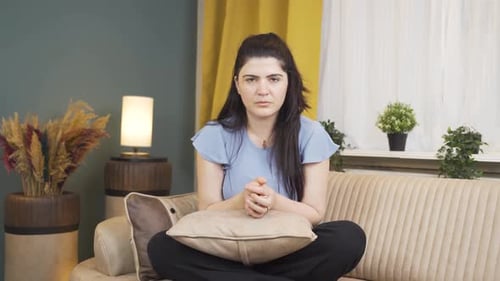 Woman Sits Cross Legged on Sofa