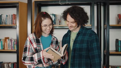 Couple Man and Girl Students Talk in the Library About Books and Classes Lots of Books in the