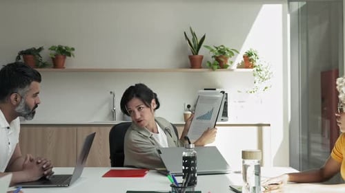 Female Business Woman Doing Meeting Presentation for a Creative Team Showing Charts Statistics and
