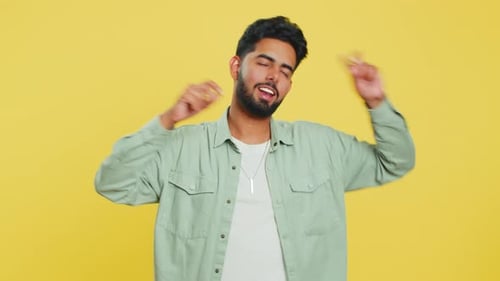 Young Man Dancing Happily on Yellow Background