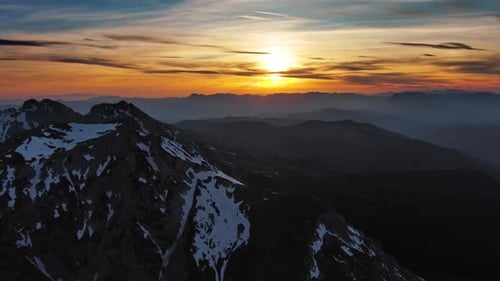 Rocky snow mountains and sunset sun