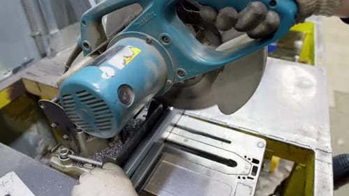 Precision Metal Cutting Engineer Using Saw on Steel Frames in a Workshop