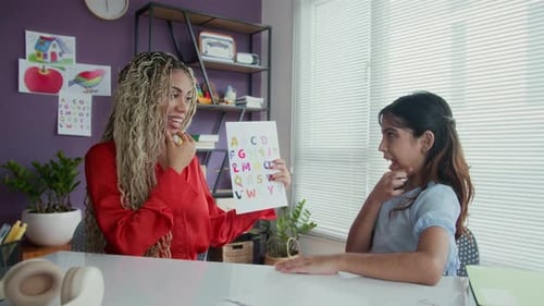 Young Adult Tutoring a Child with Alphabet