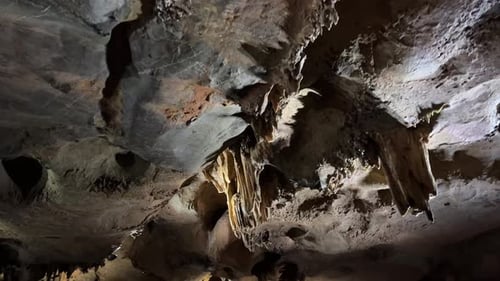 L'intérieur de la grotte est faiblement éclairé et met en valeur les formations rocheuses naturelles.