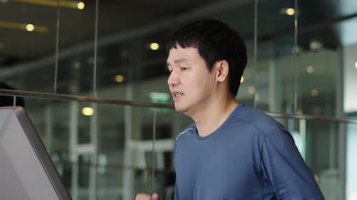 slow motion of young man running on treadmill at fitness gym exercise