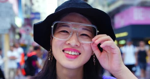 Portrait of Young Trendy Asian Woman at Camera in the Street Of