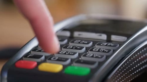 Hand Entering Pin on Credit Card Reader