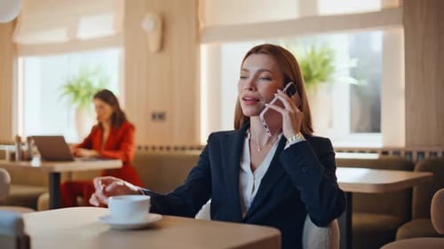 Confident Businesswoman Talking Cellphone in Cafeteria at Coffee Break Closeup