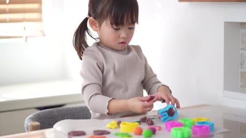 Little Girl Playing with Modeling Clay Indoors