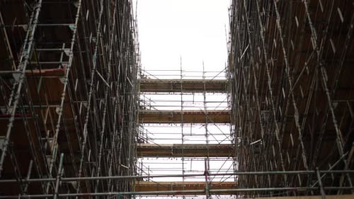 Contemplando un andamiaje alto en un rascacielos de un edificio en construcción o renovación, en una nube