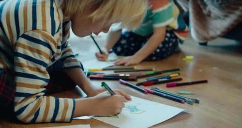 Children Drawing Together on the Floor