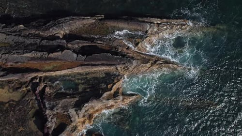 Overhead View of Waves Splash on Rocks
