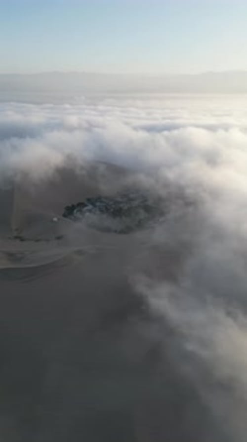 Aerial video above fog in the dunes of Huacachina Peru