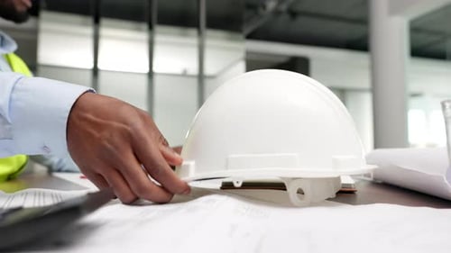 Architect, technician and civil engineer putting on his hardhat for safety