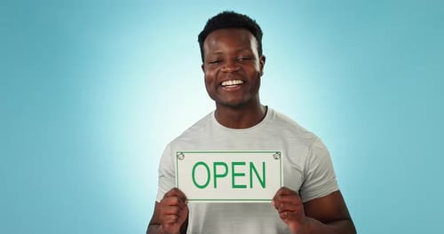Happy black man, open sign and advertising in welcome or ready for service against a blue