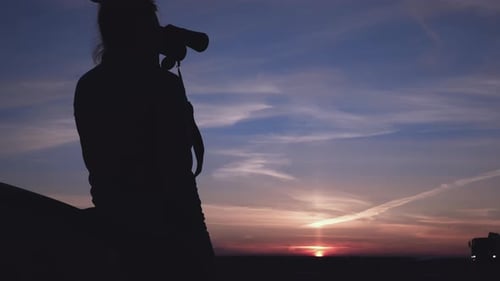 Silhouette Gazing at Sunrise with Binoculars in Nature