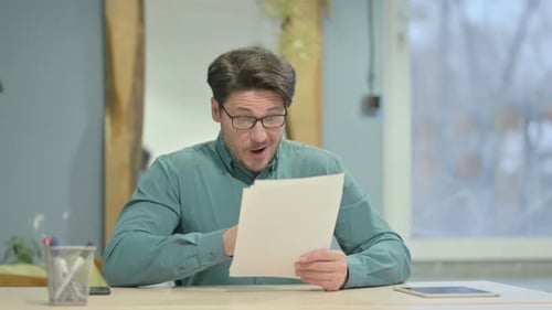 Man Reviews Documents and Reacts Positively