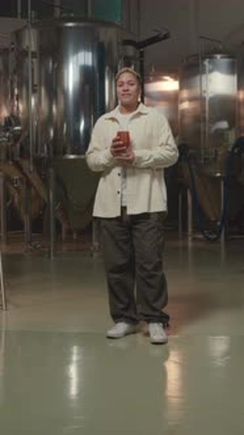 Woman Holding Glass in Stainless Steel Factory