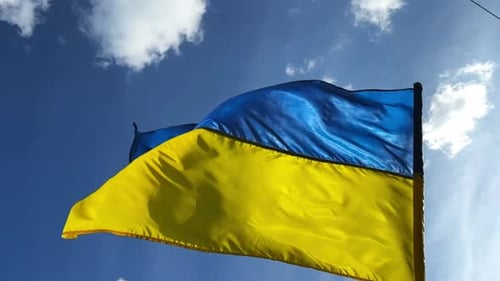 Ukrainian Flag Waving in the Wind Under Blue Sky