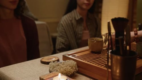 Tea ceremony with friends and candlelight indoors