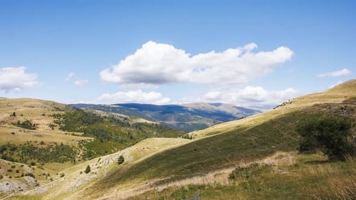 Wolken ziehen über grüne Hügel im Zeitraffer in Coll De La Creueta, Barcelona, Spanien