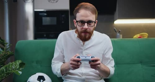 Man with Controller Playing Video Game on Couch