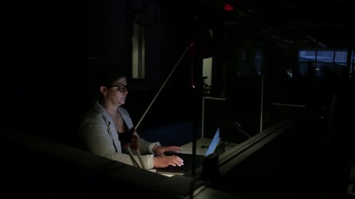 Dedicated Businesswoman Working Late At Laptop In Dark Office